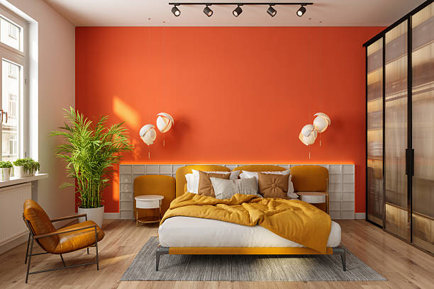Bedroom with a bold terracotta accent wall and bright white trim by a house painter in Germantown, MD.