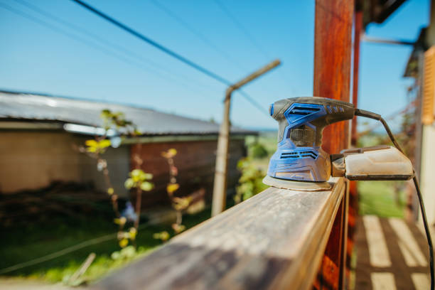 Close-up of sanding exterior wood railing during surface preparation by an exterior painter in Frederick, MD